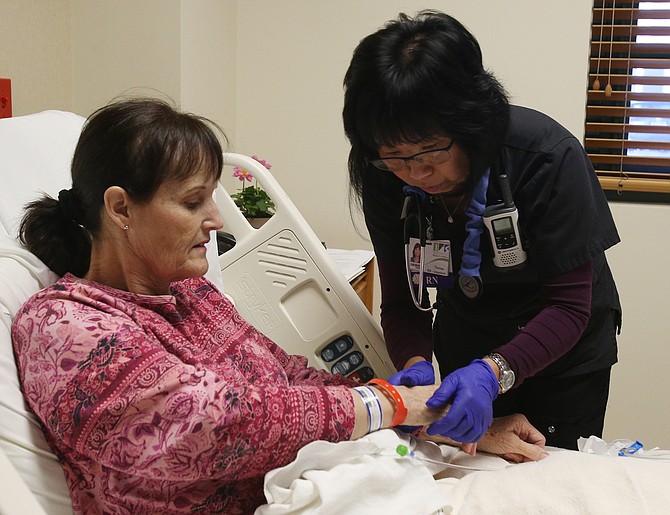 Registered nurse Teresa Gammond helps discontinue an IV for Dixie Brewer at Northwest Specialty Hospital.