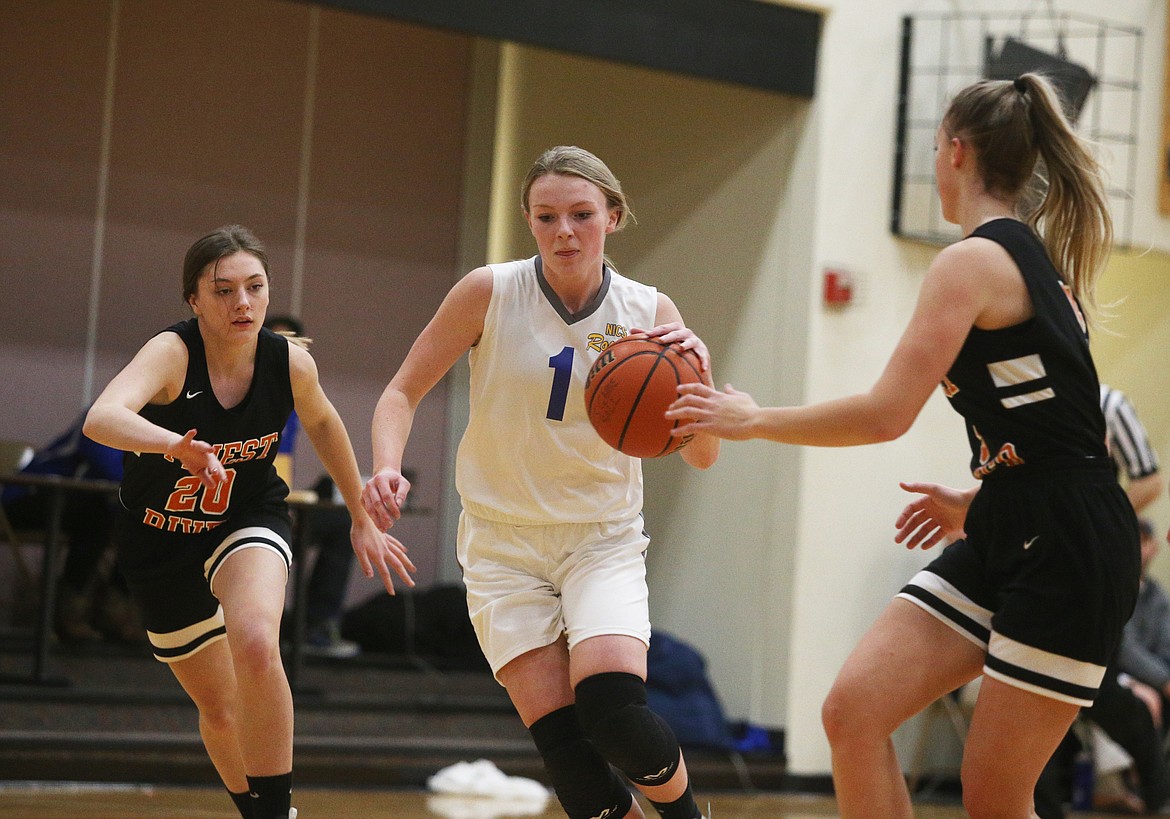 North Idaho Christian guard Courtney Monaghan dribbles the ball between Priest River defenders Cassidy Prudek, left, and Maddy Rusho.