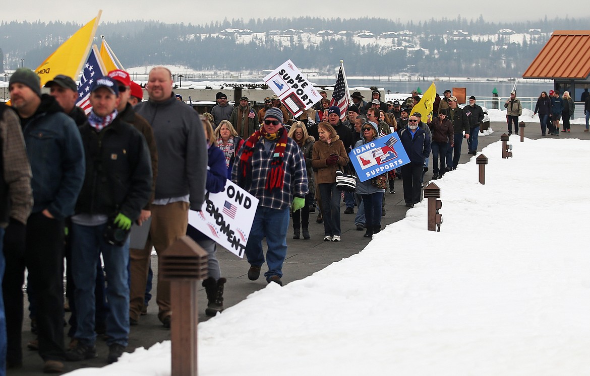 Hundreds of people walk from the Coeur d’Alene Resort clock tower to McEuen Park to attend a Second Amendment rally on Monday.