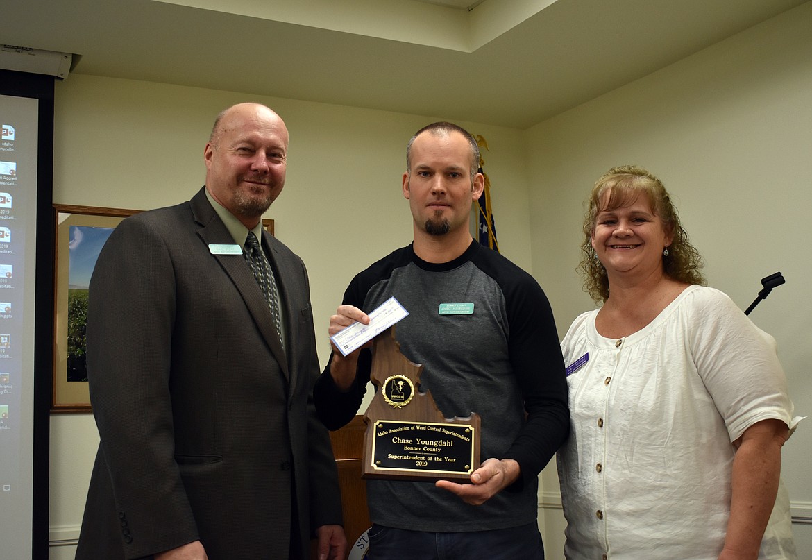 Chase Youngdahl, center, is presented with his award after being named the Idaho Weed Superintendent of the Year recently.