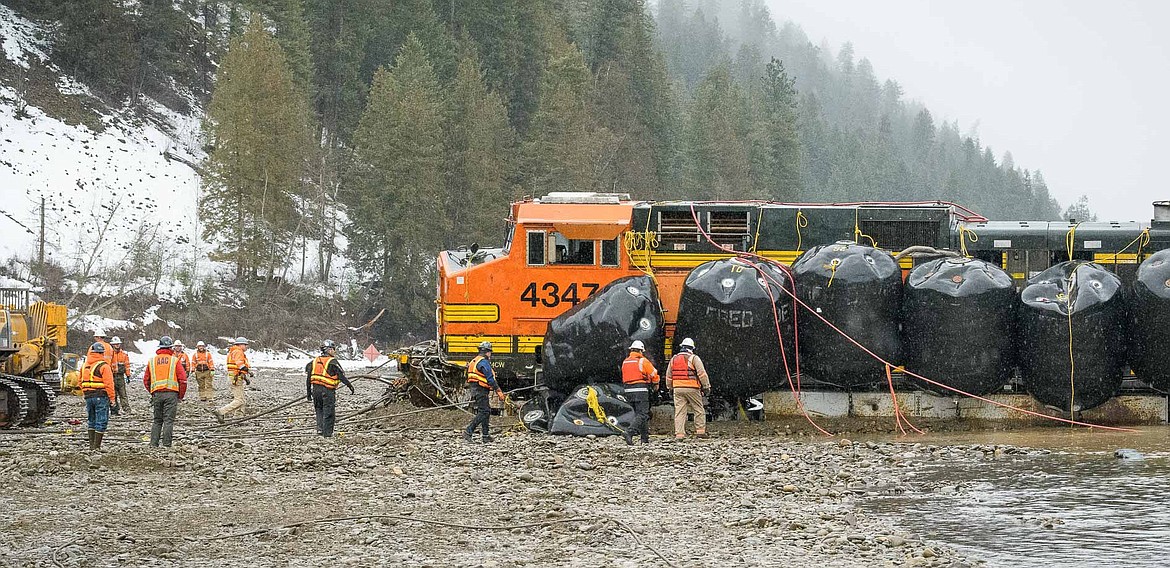 The derailed BNSF locomotive which fell into the Kootenai River arrives on the north shore, thanks to large airbags attached to the train by divers.