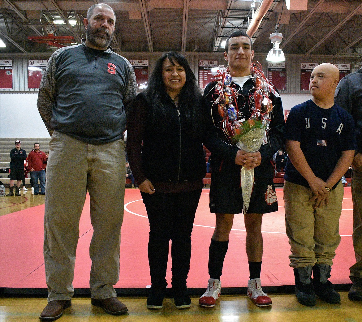 (Photo by DYLAN GREENE) 
 Isaiah Caralis celebrates senior night with his family.