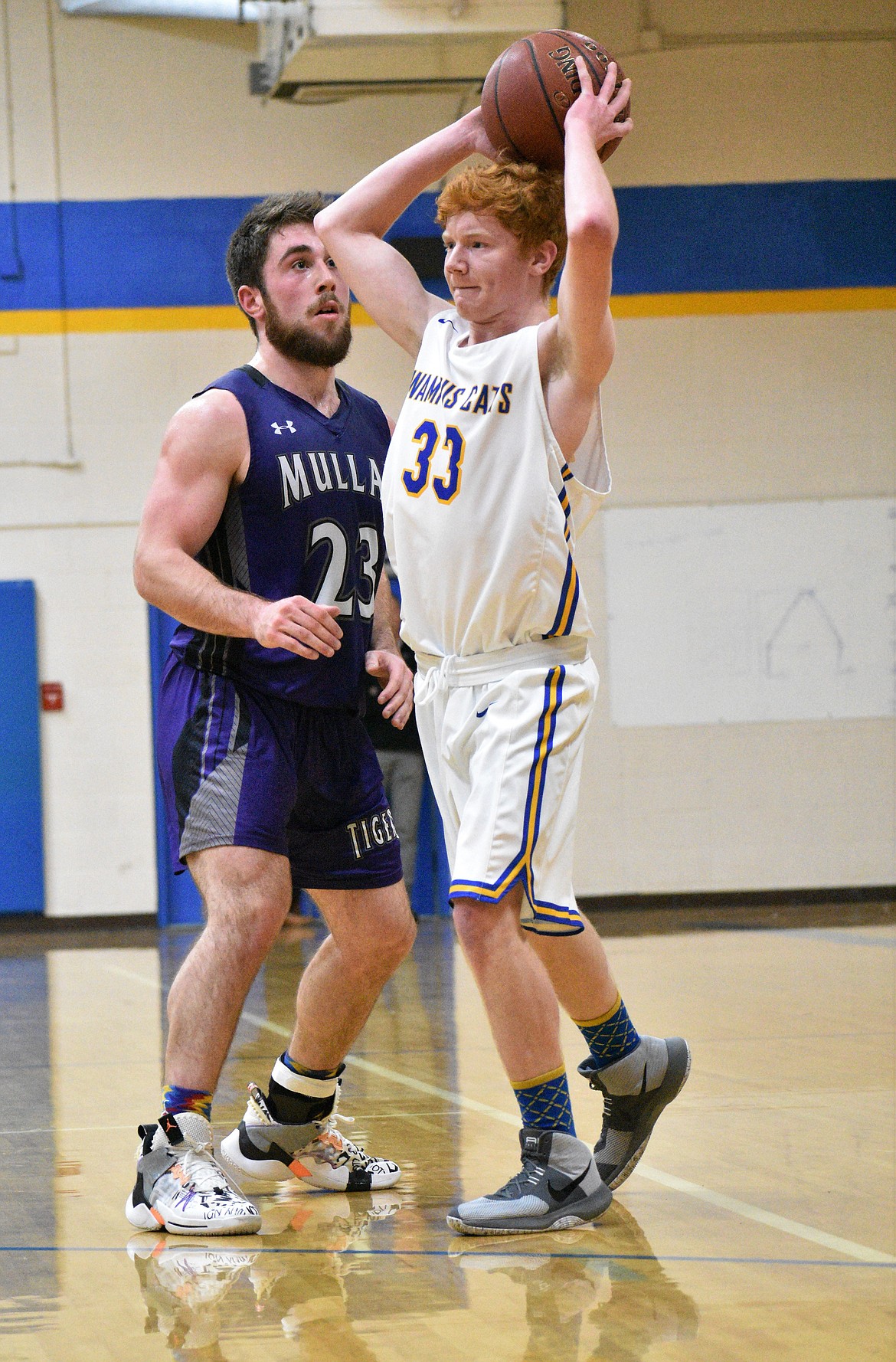 Senior Isaac Steele tries to pass the ball to a teammate as a Mullan player defends him Thursday night.