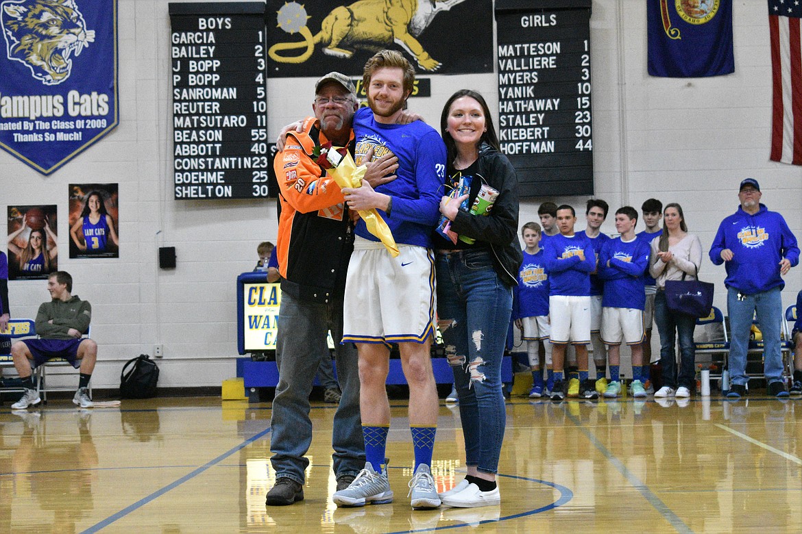 (Photo by DYLAN GREENE) 
 Senior Josh Constantin celebrates senior night with his dad and girlfriend.