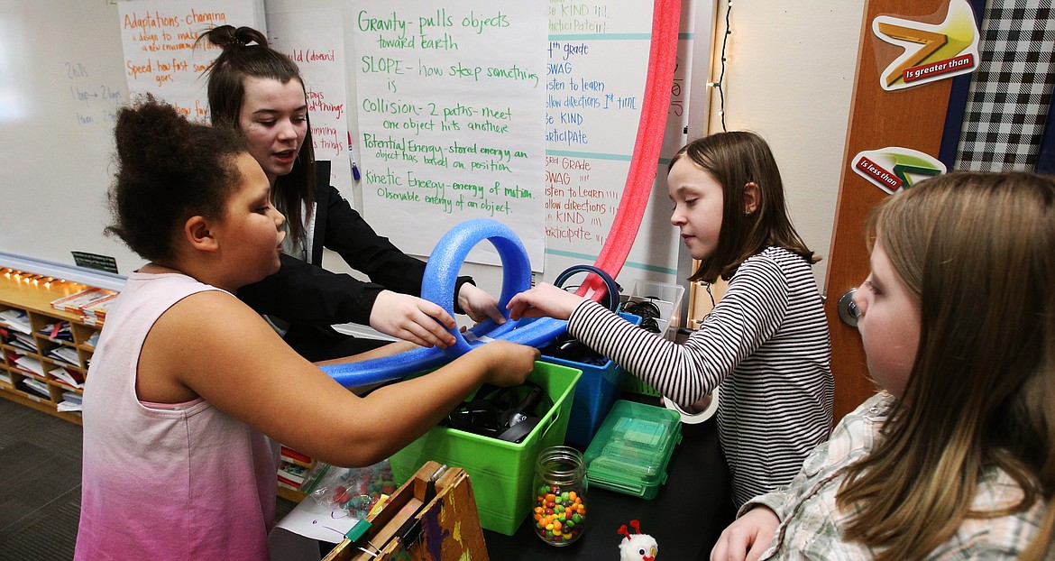 Coeur d’Alene High School freshman Saray Goode, second left, helps Borah students Taliyah Campbell, left, Trinity Price, far right, and Danica Martzall make a roller coaster during STEM club after sc