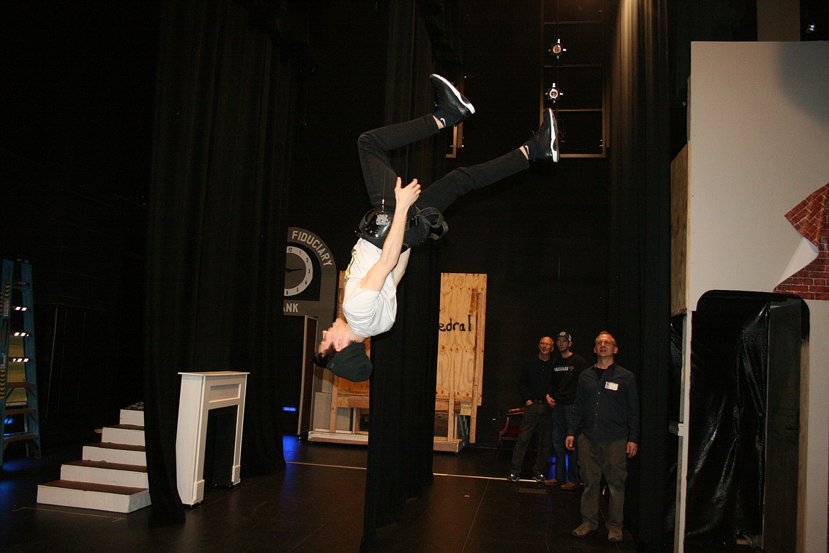 Taylor Street (upside down) practices flipping through the air. Street plays Bert in the Quincy Valley Allied Arts production of “Mary Poppins.”