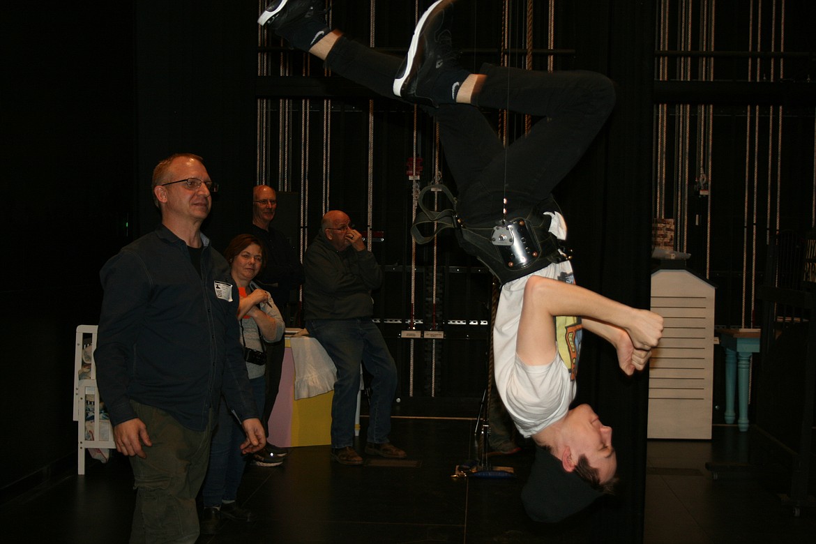 Taylor Street (upside down), cast as Bert, gets a lesson in acrobatics from flying director Mark Kostuch (left). The Quincy Valley Allied Arts production of “Mary Poppins” opens Feb. 20.
