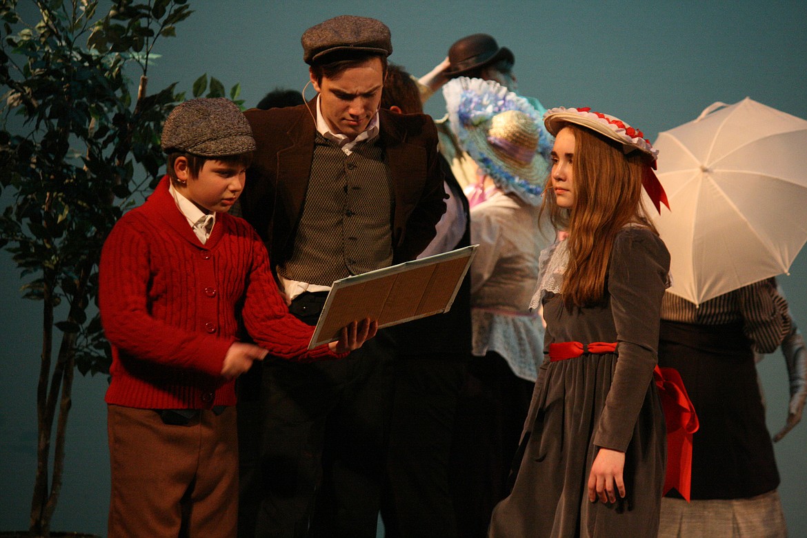 Cheryl Schweizer/Columbia Basin Herald | Bert (Taylor Street, center) tries to help Michael Banks (Lev Rosberg, left) and his sister Jane (Emma Foley, right) find the magic in the painting in the Quincy Valley Allied Arts production of “Mary Poppins.”