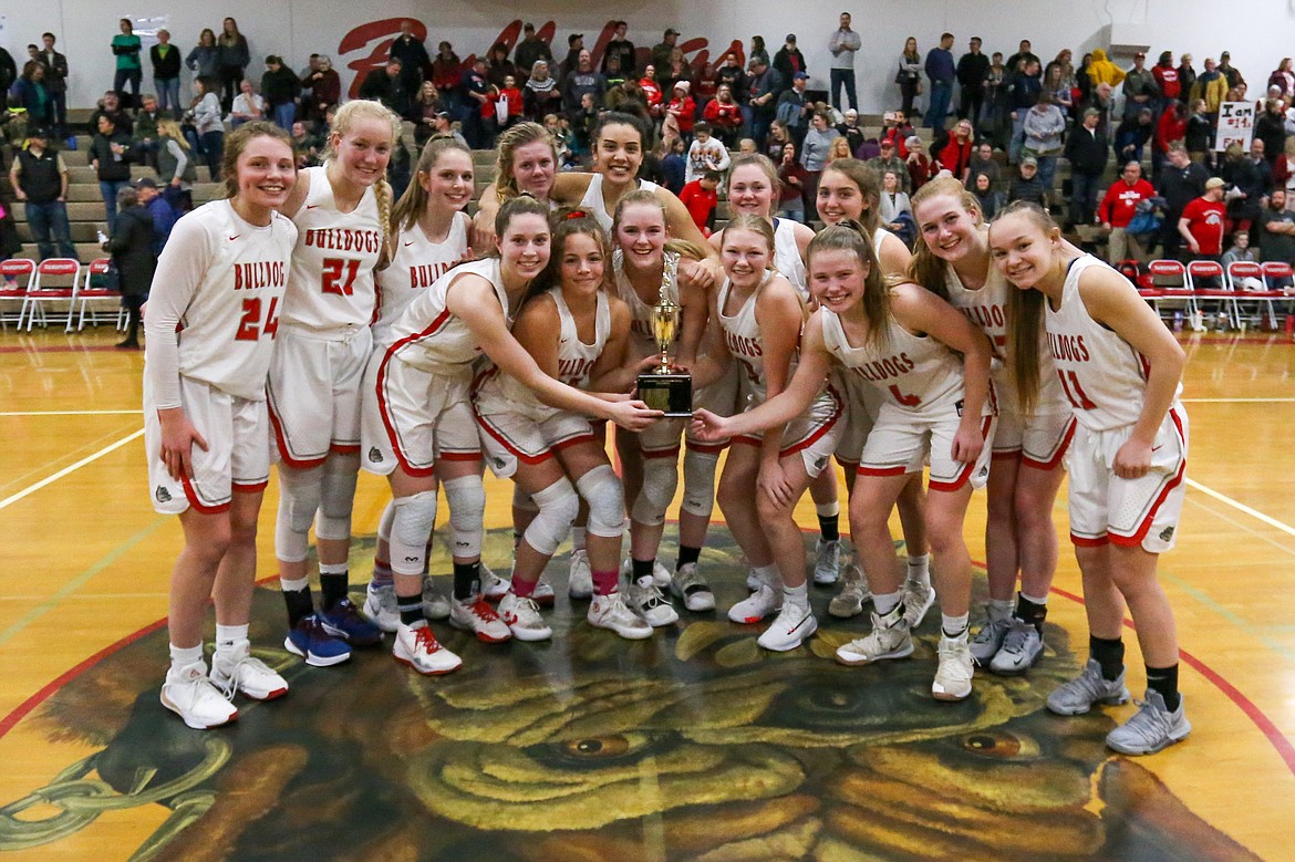 (Photo courtesy of JASON DUCHOW PHOTOGRAPHY) 
 The Sandpoint girls basketball team poses for a group photo with the district championship trophy after taking down Lakeland 48-44 Friday night. The Bulldogs are now heading to state.