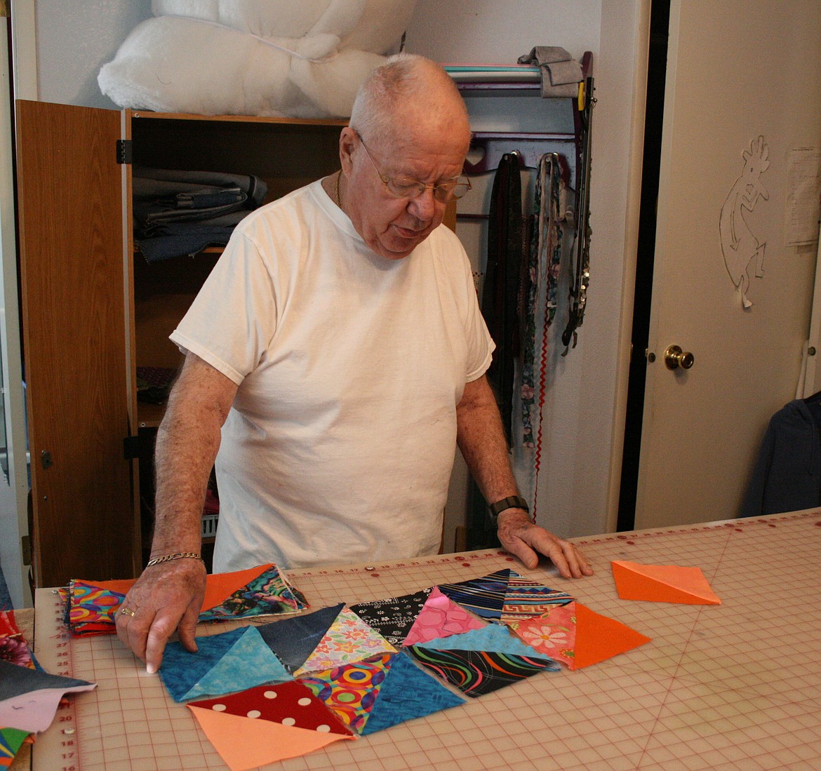 Mel Neal rearranges quilt blocks for the most eye-catching design. Neal and his wife Max have made more than 800 quilts for donation to the Columbia Basin Cancer Foundation.