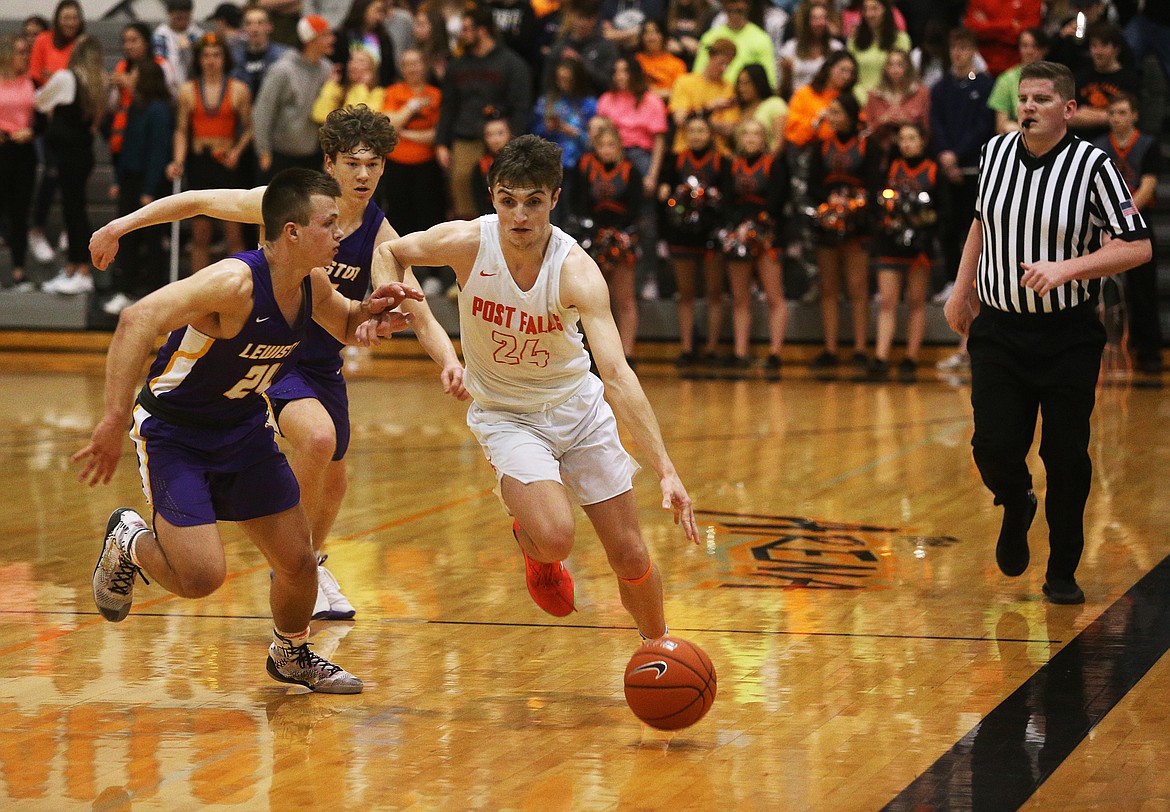 Post Falls High's Alex Horning dribbles the ball along the side of the court while defended by Lewiston's Kash Lang (15) and Cruz Hepburn (24) in the 5A Region 1 championship game Wednesday at Post F