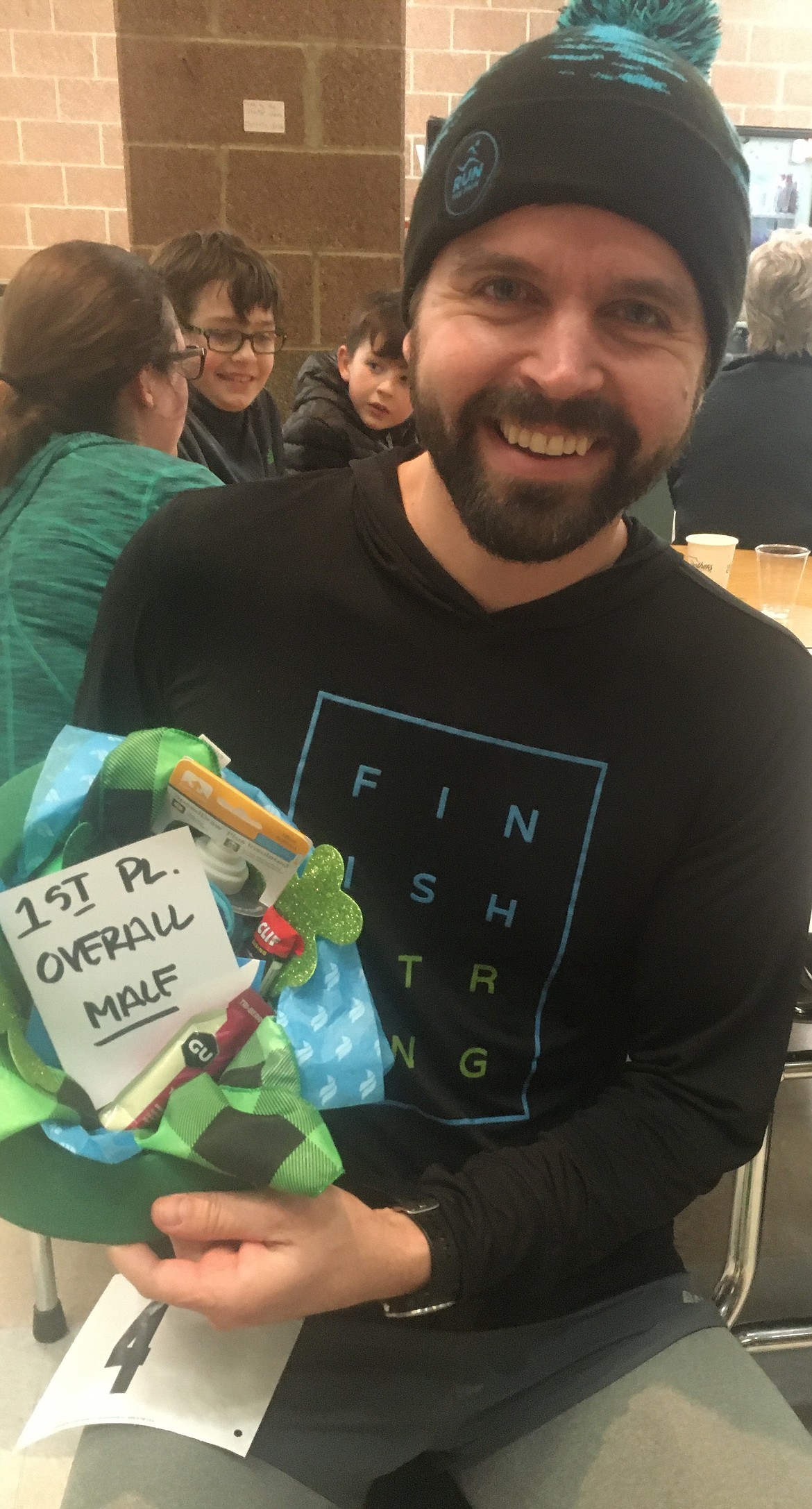Josh Emery of Rathdrum holds up his prizes for winning the Leprechaun Scurry on Saturday at Lake City High School.
