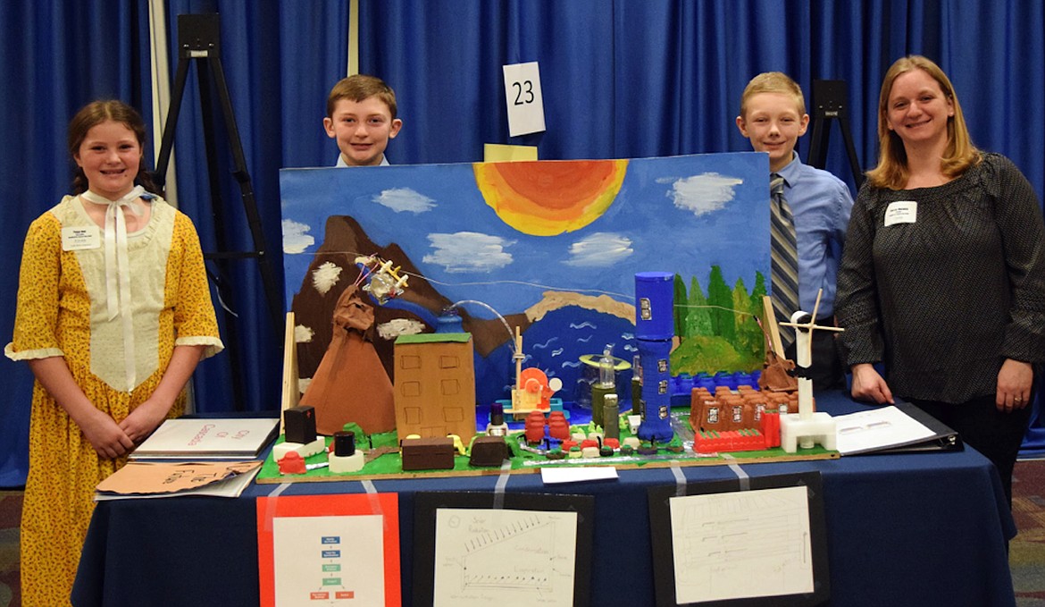 Team Cascadia team members Paige Rief, Colter Cates, and Hunter Burrows pose with Jeanne Warwick from Northside School, who lead a group of Bonner County students at the recent Future City competition at Boise State University.