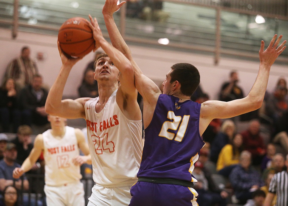 Post Falls High’s Alex Horning drives toward the basket for a score while defended by Lewiston’s Joel Mullikin during the 5A Region 1 championship game on Feb. 26 at The Arena at Post Falls. The Trojans (20-3) will face Timberline (11-15) of Boise on Thursday in the tourney opener at 12:15 p.m. PST at the Ford Idaho Center in Nampa.