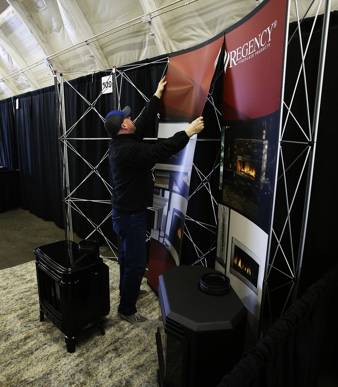 John Hoffman helps setup a display at the Regency Fireplace booth Thursday before today's Home and Garden Show at The Kootenai County Fairgrounds. (LOREN BENOIT/Press)