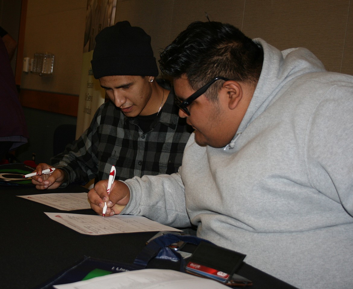 Brayan Sandoval, right, and Joseph Sanchez, both of Othello, fill out applications during the Job and Career Fair at Big Bend Community College Thursday.