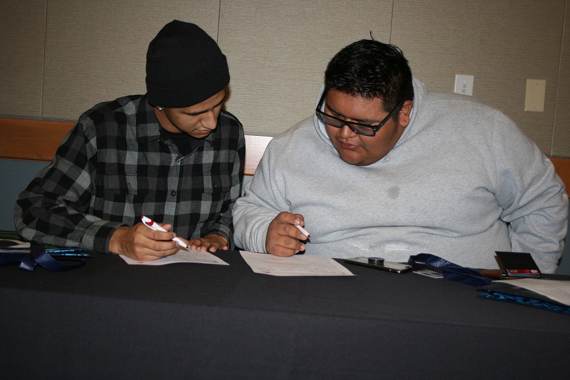 Joseph Sanchez (left) and Brayan Sandoval, both of Othello, fill out applications at the Job and Career Fair Thursday at Big Bend Community College.