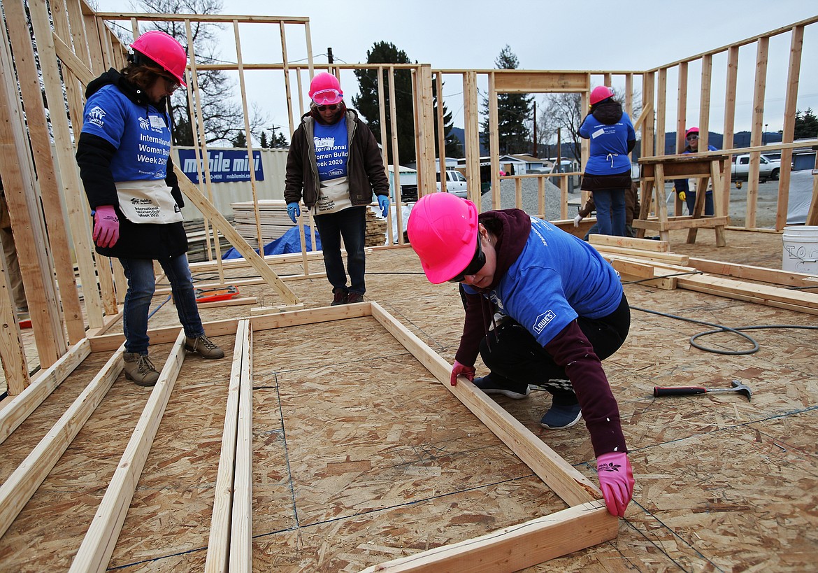 Lowe’s merchandise associate Bobbie Helling, left, garden associate Lori Heimbigner, center, and Habitat for Humanity volunteer Chelsea Glavin line up a wall for a house during Habitat for Humanity’s International Women Build event on Friday.