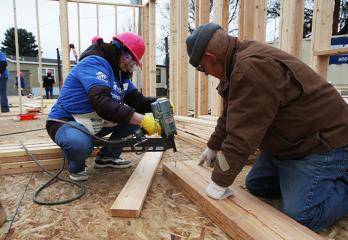 Lowe’s employee Lisa Thornton and volunteer Tom Collier build a header for a window during Habitat for Humanity’s International Women Build week.