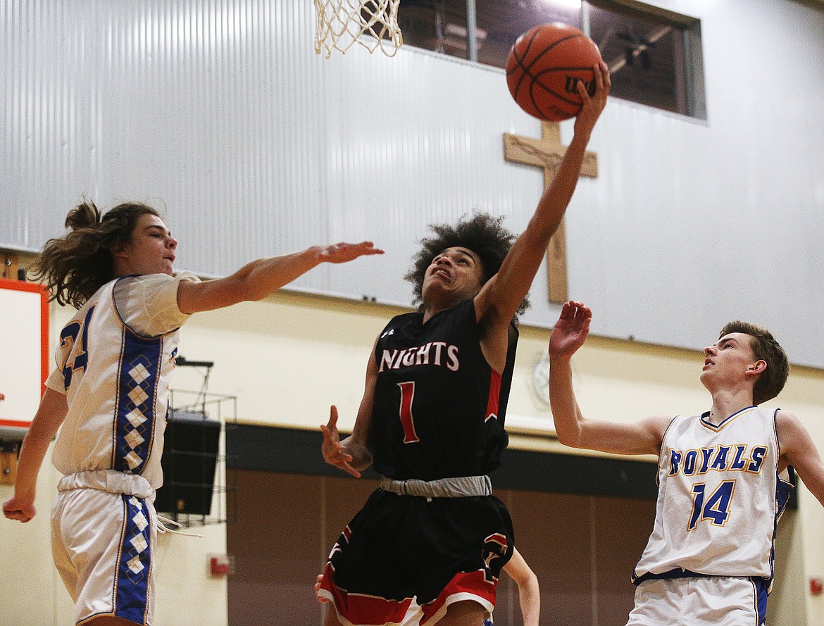 Lakeside Knights’ Vander Brown scores a layup between North Idaho College defenders in a game at Holy Family Catholic School on Feb. 3.