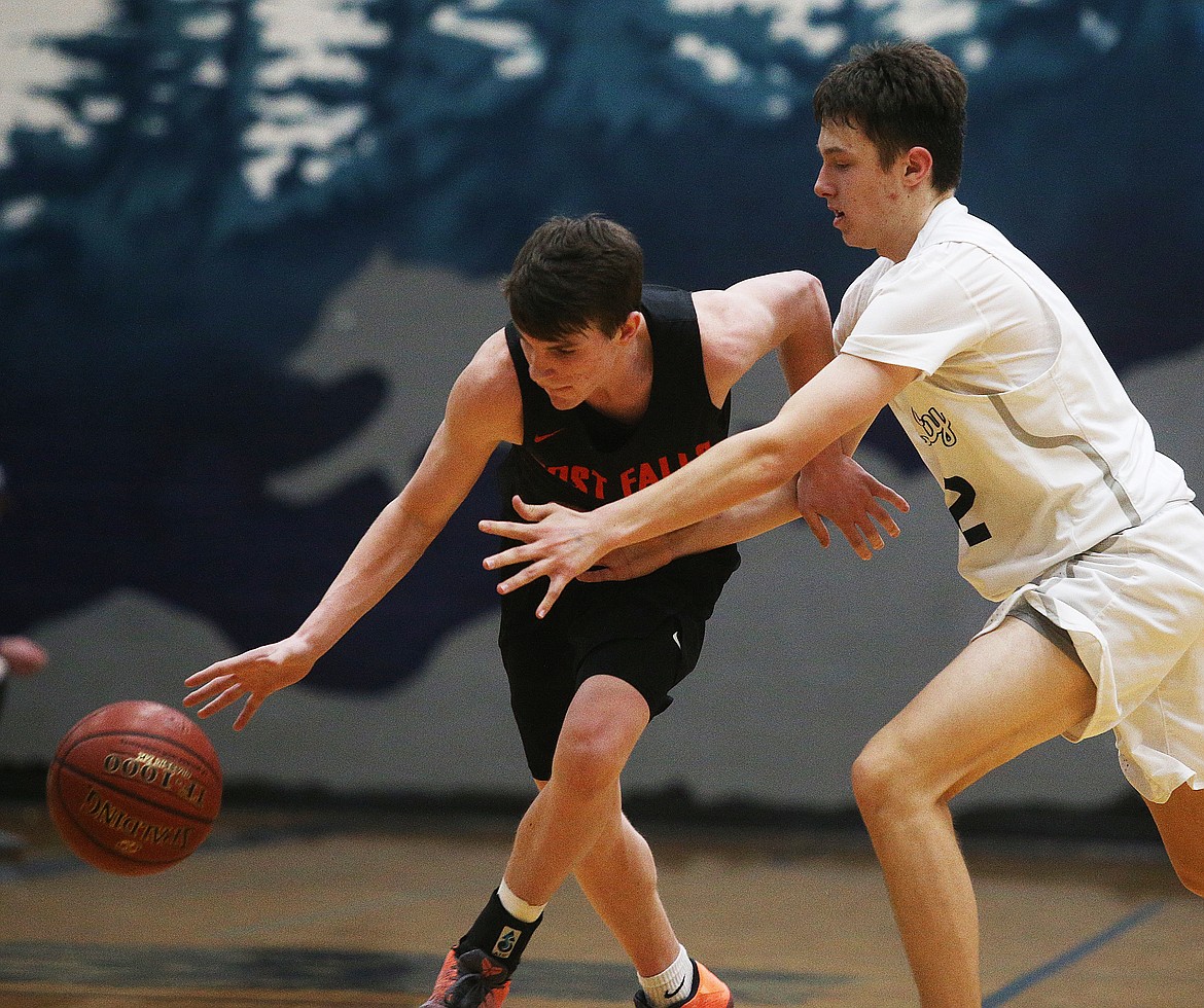 Post Falls’ Cole Rutherford dribbles the ball down the court while defended by Lake City’s Seth Hanson in a game at Lake City on Feb. 14.