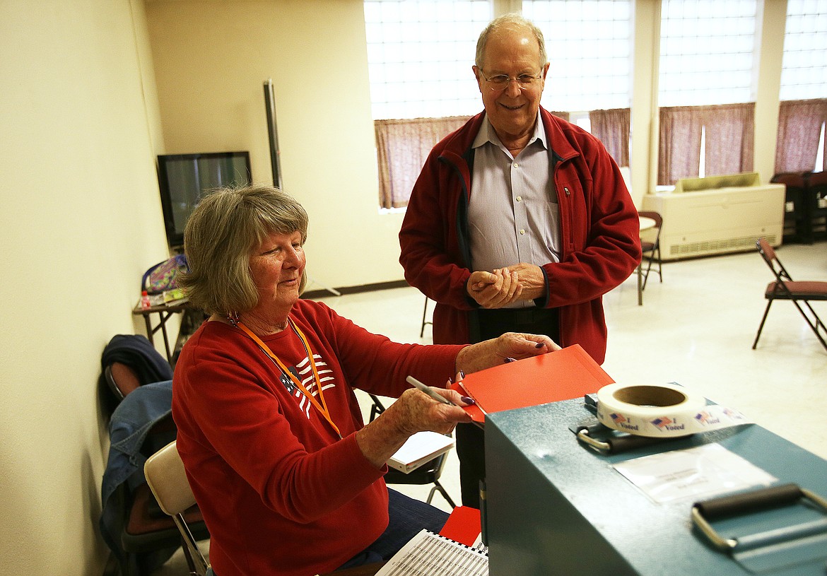 Chief judge Lorna Wasson helps Robert Luten cast a ballot during Tuesday’s presidential primary at St. Thomas parish center in Coeur d’Alene.