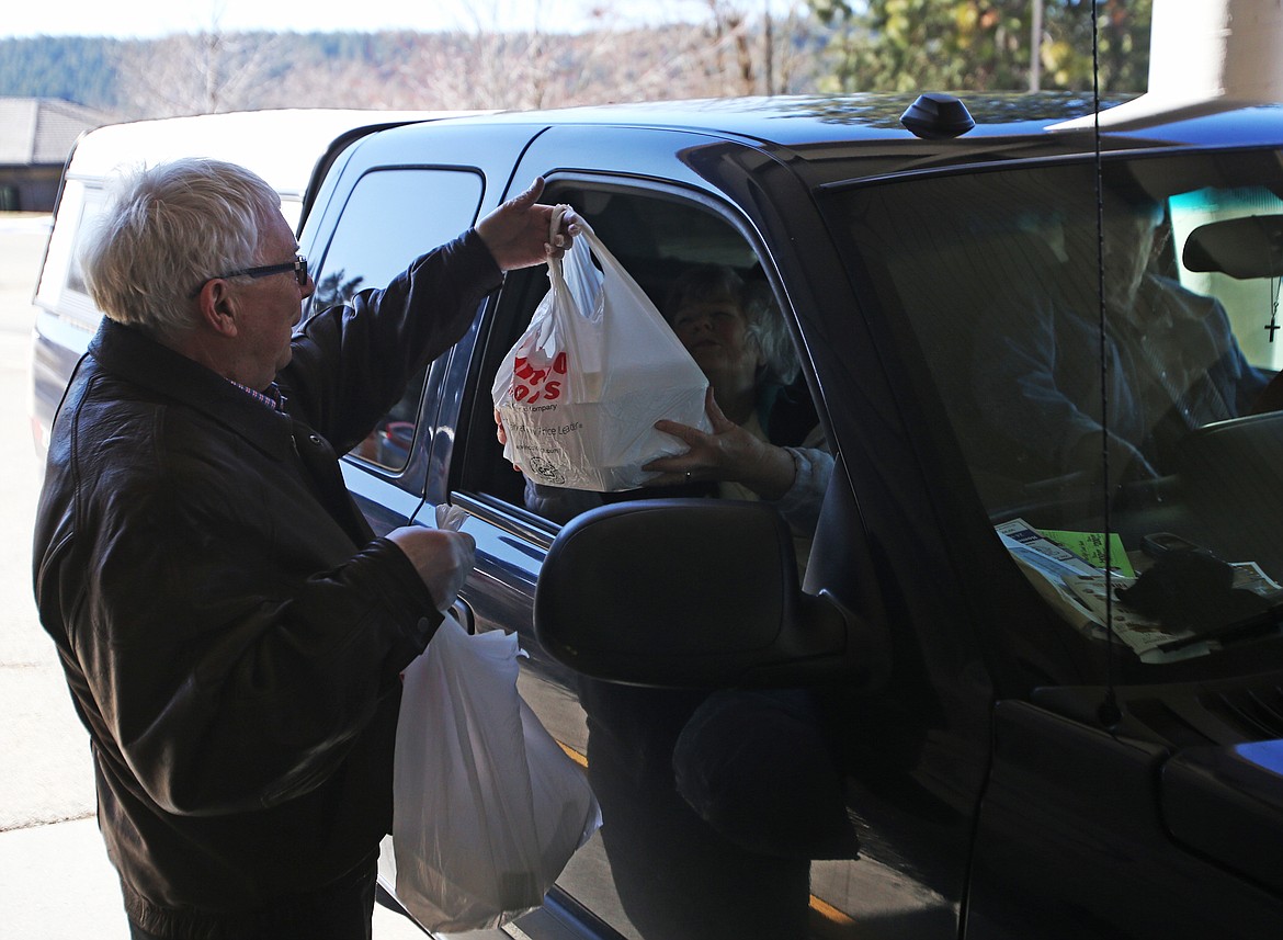 Leroy and Marcia Murray receive their meals from Lake City Center director Bob Small during lunch hour Tuesday. The center started offering the drive-thru boxed lunch service for safety and peace of mind for its patrons.