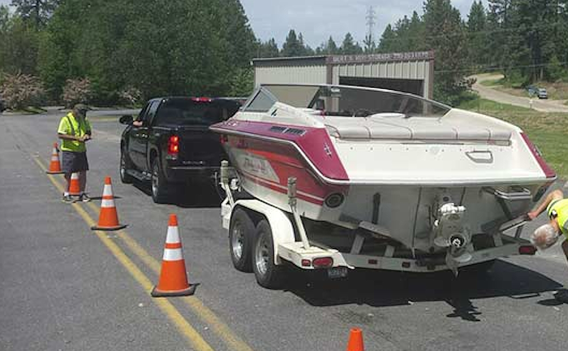 Inspectors examine a boat at a mandatory inspection station.