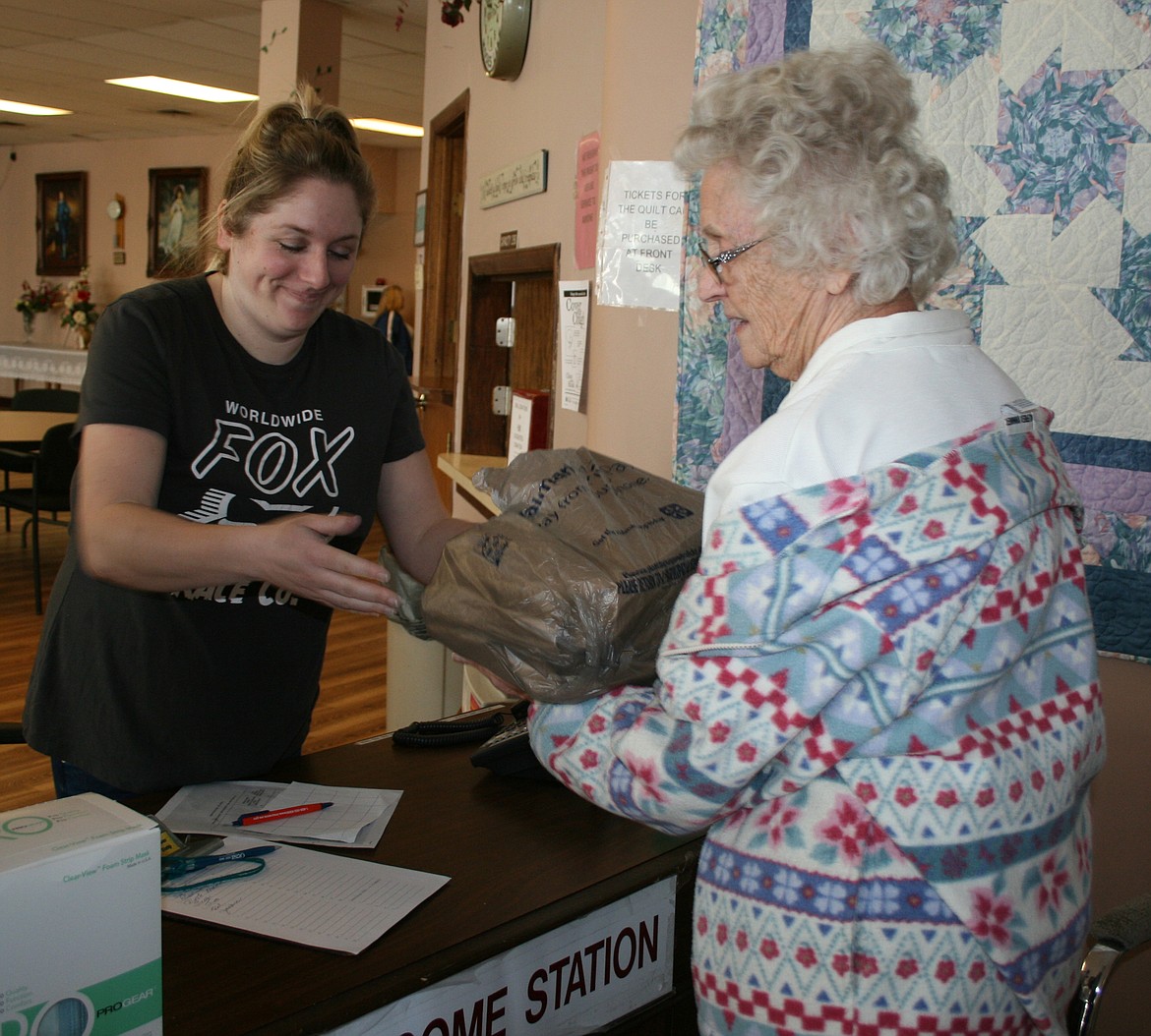 Jackie Chase (right) picks up a hot lunch from Moses Lake Senior Center cook Amanda Argento. Senior centers throughout the Columbia Basin have closed in response to the COVID-19 outbreak.