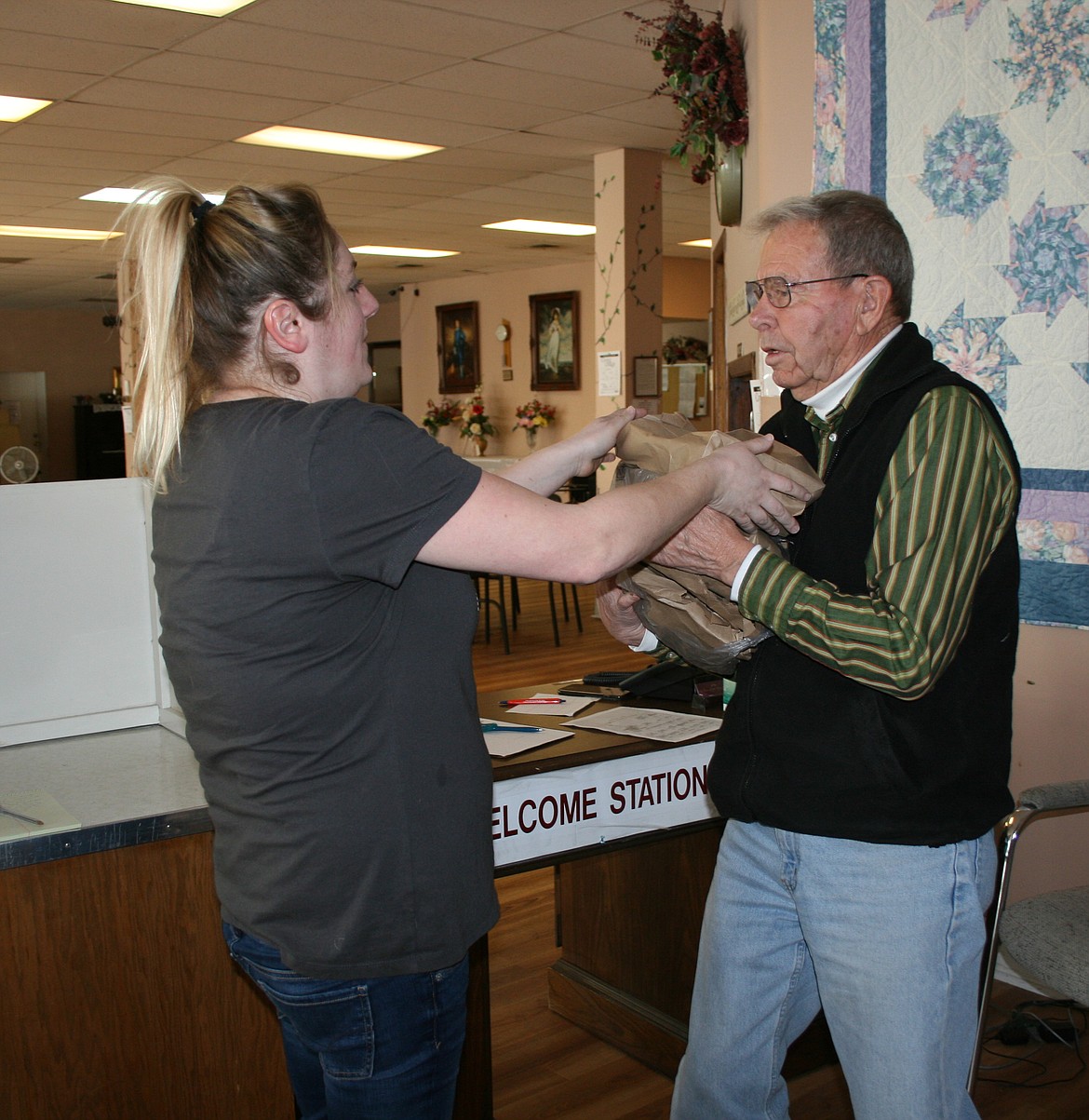 Moses Lake Senior Center cook Amanda Argento (left) gives a hot meal to Allan Sweet. Senior centers throughout the Columbia Basin have been forced to close as a result of the COVID-19 outbreak.