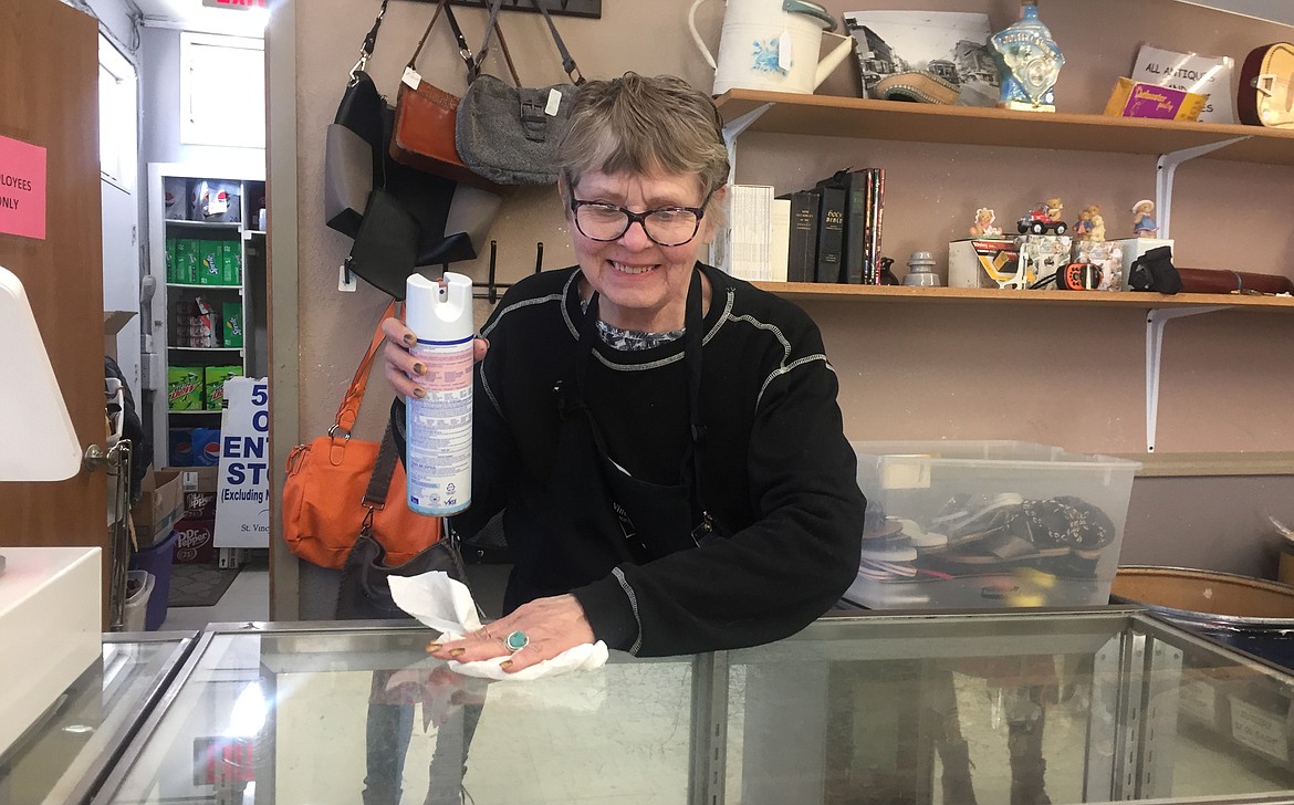 Orvella Kendall sanitizes the check-out counter at the St. Vincent de Paul thrift store in Coeur d’Alene. Employees are trying very hard to ensure customer safety in the store.