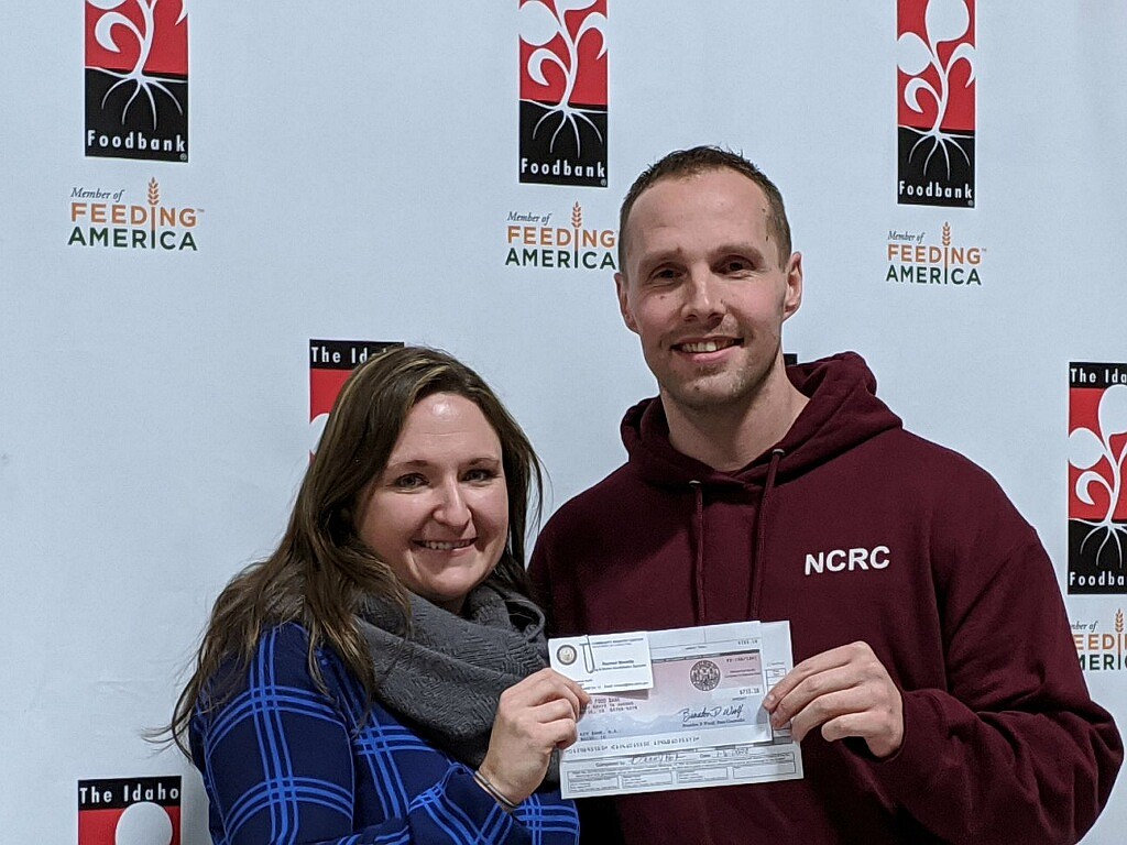 Devin Ponte presents a donation to an Idaho Foodbank with money raised by a fundraiser at the Nampa Community Re-entry Center. (Photo Courtesy of the Idaho Department of Corrections)