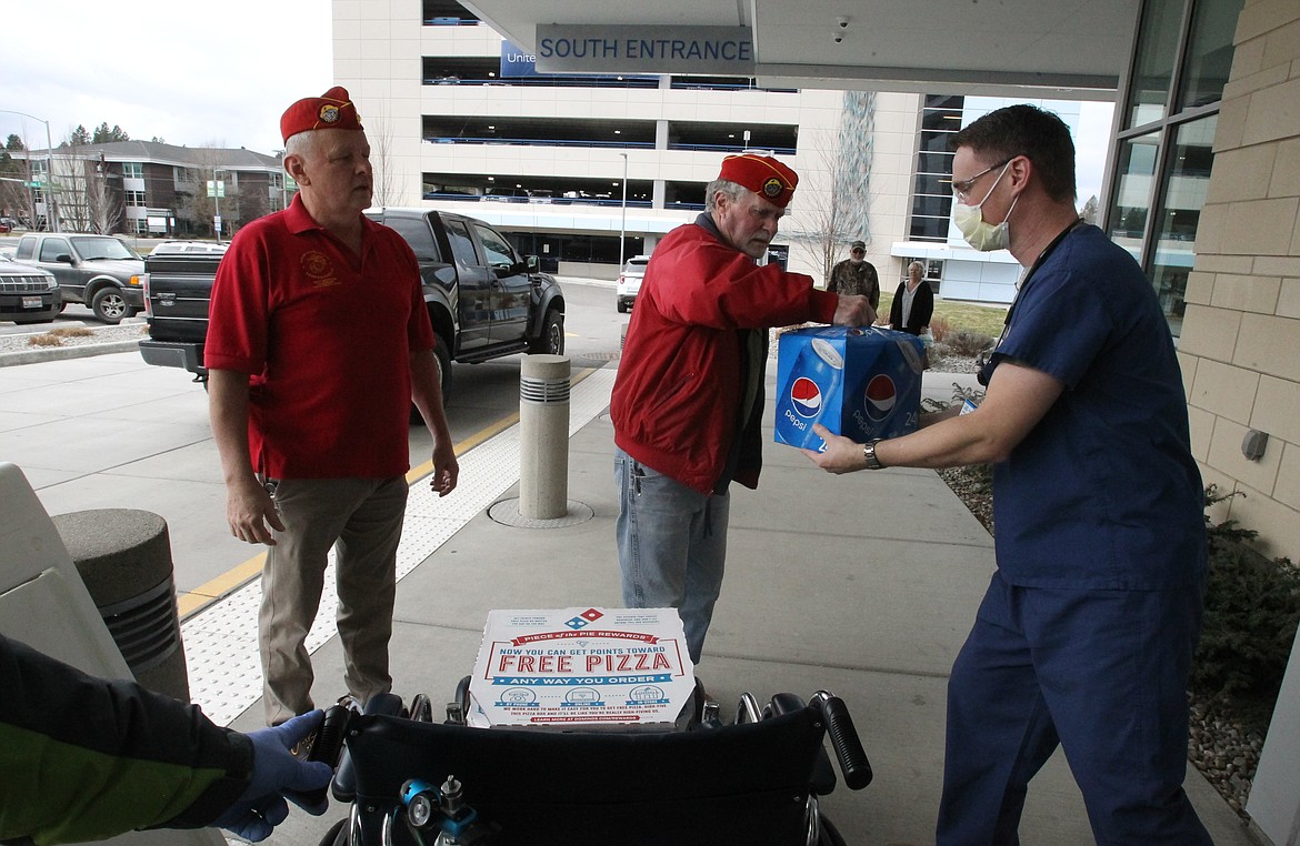 Dr. Patrick Magajna accepts pizza from veterans Mike Quinn, center, and Ron Barnett on Friday at Kootenai Health.