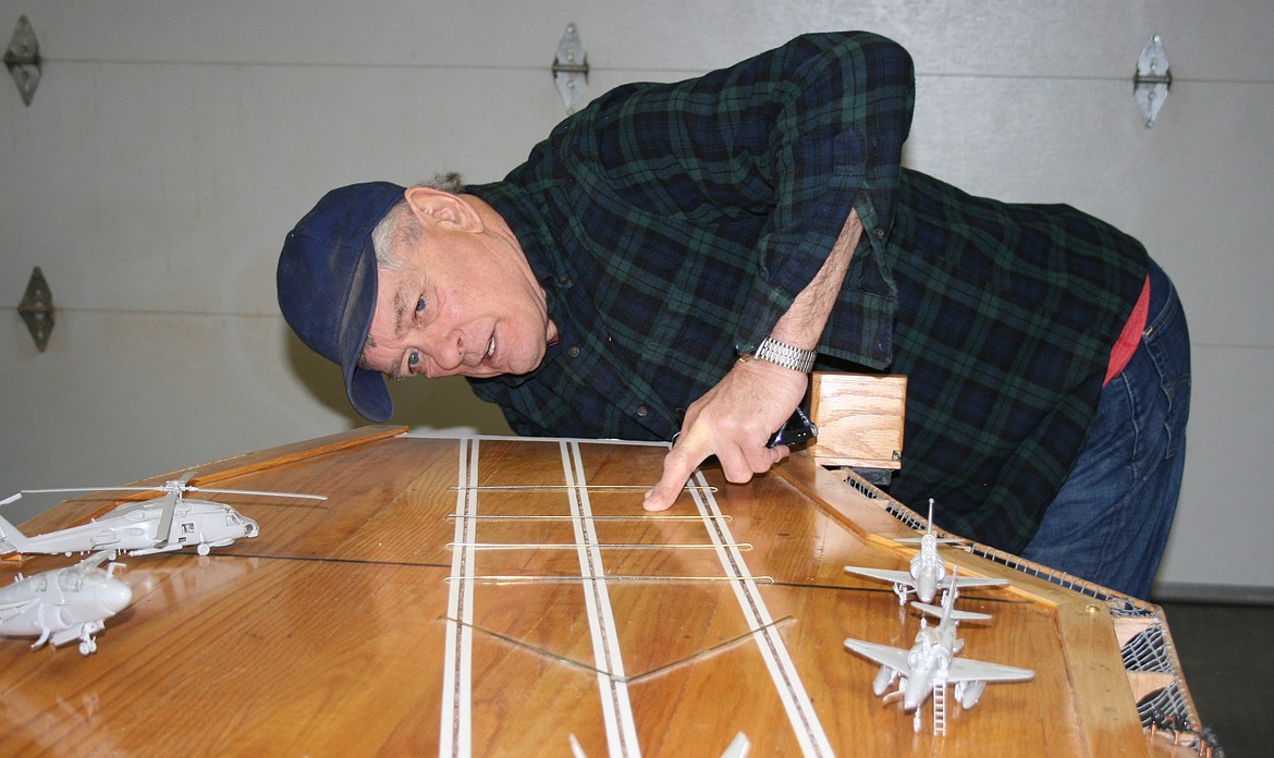 Robin Major turns on the landing lights on the replica he built of the aircraft carrier USS Bennington.