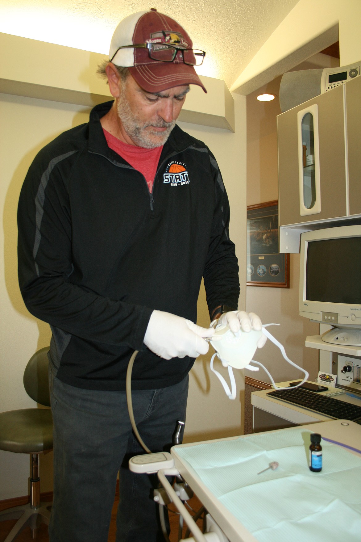 Cheryl Schweizer/Columbia Basin Herald 
  
 Craig Harder adjusts the fit on a reusable N95 mask. While his dental office is closed, Harder is making masks for medical professionals using his 3D printer.