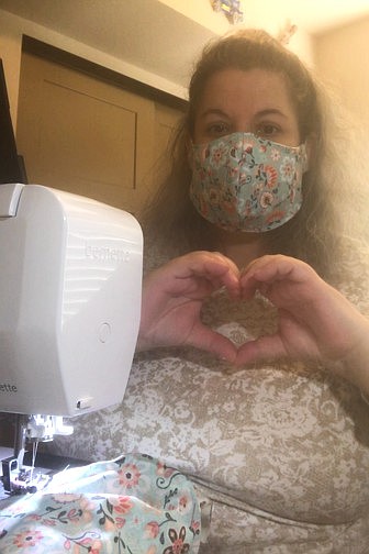 Post Falls resident Dusti Bacon makes a heart with her hands as she sends love and homemade masks out into the community. (Courtesy photo)