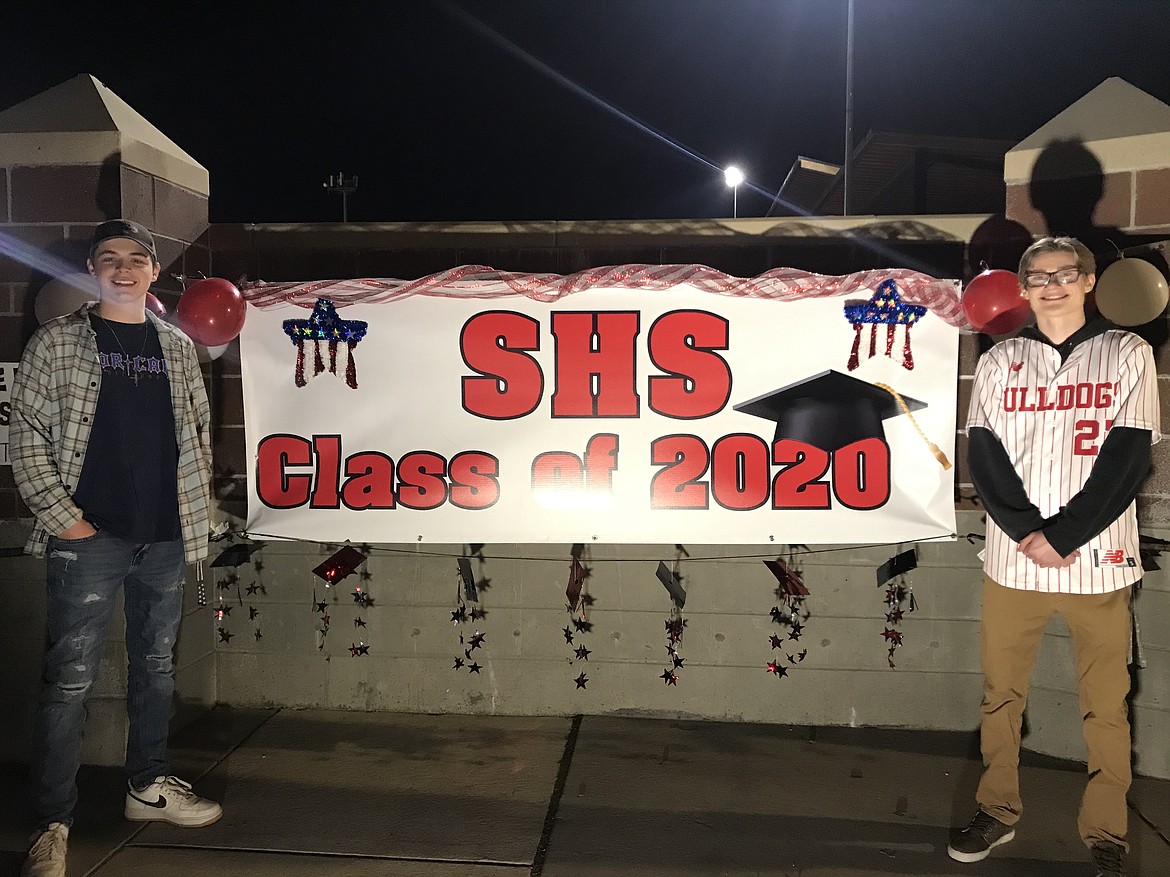 (Photo courtesy of DEBBIE EDLUND) 
 Seniors Colton Lunde (left) and Ethan Edlund pose for a photo in front of the banner honoring the senior class at Friday's "Be the Light" event.