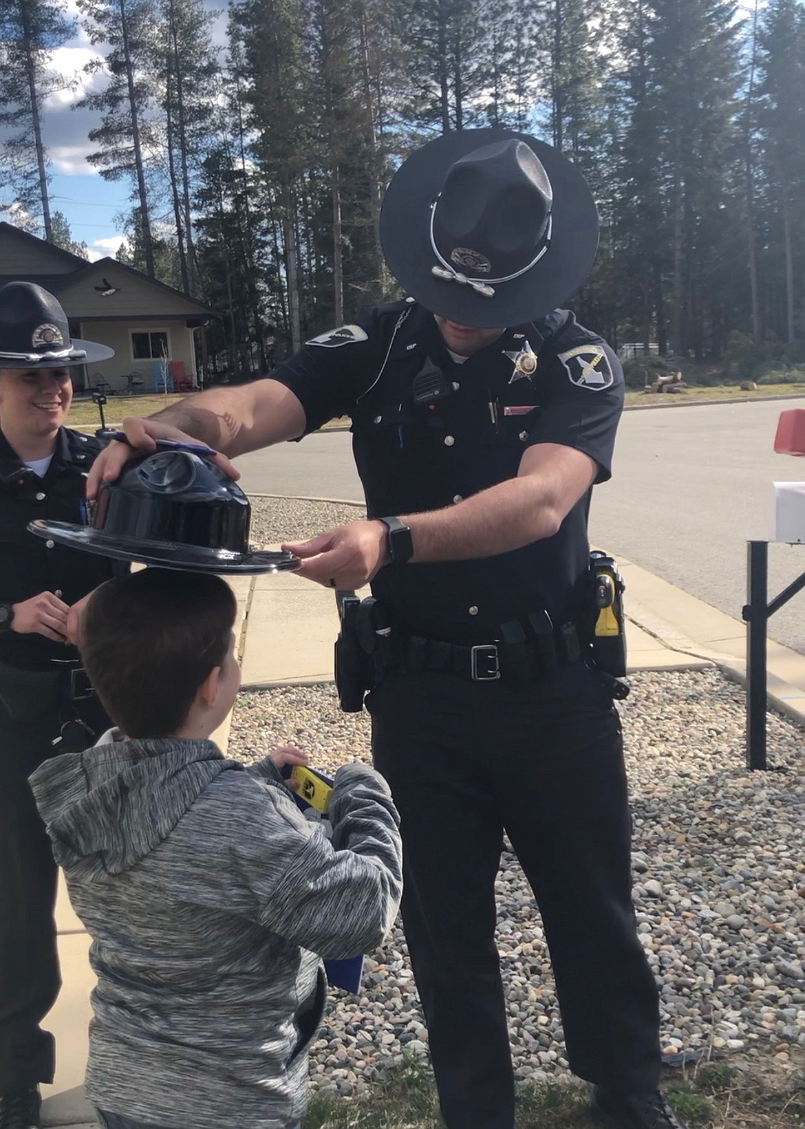 An Idaho State Police trooper gives Jackson Reynold his own “covers” as after a special parade to wish the now-8-year-old a happy birthday. His original birthday party had to be canceled because of the stay-at-home order issued in Idaho as a result of the COVID-19 pandemic.