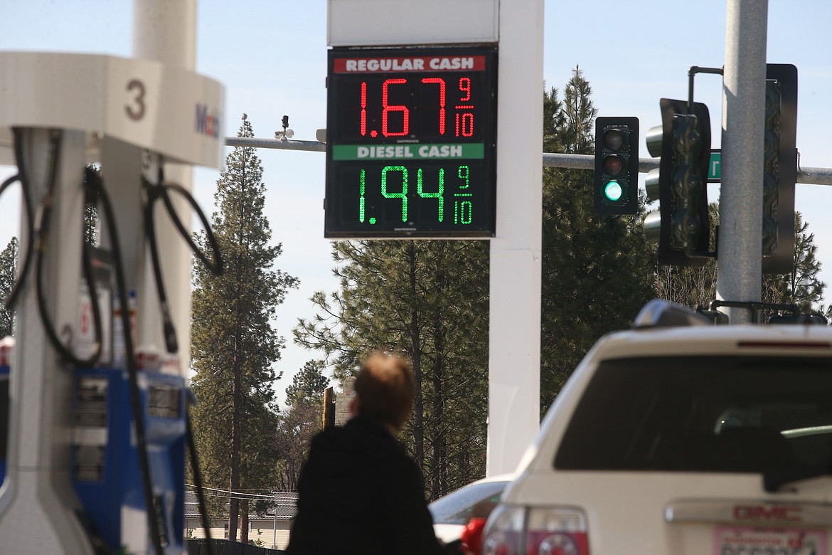 A driver fills up their vehicle in Coeur d’Alene on Monday. Gas prices have been falling in Idaho to their lowest levels in years.