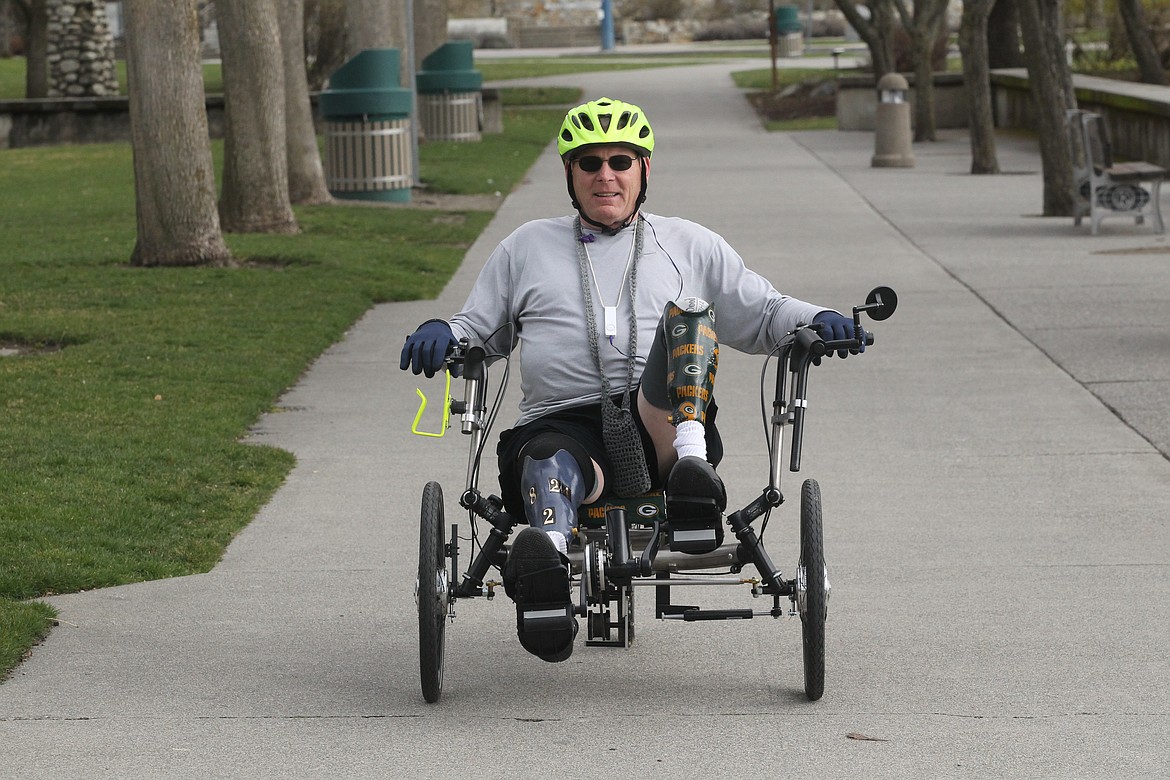 BILL BULEY/Press 
 Charlie Hughes displays his Packer pride as rides his recument bike through Coeur d'Alene City Park.