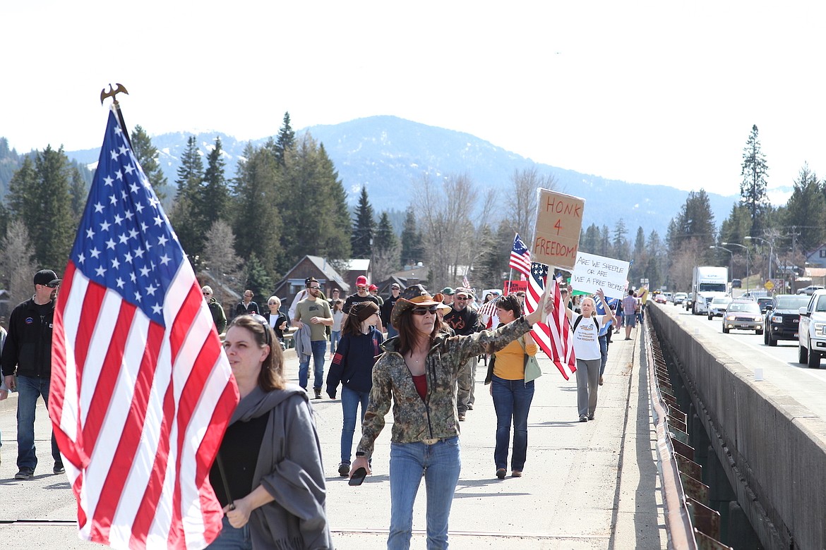 Protesters of Idaho’s stay-at-home order walk across the Long Bridge in Sandpoint on Friday.