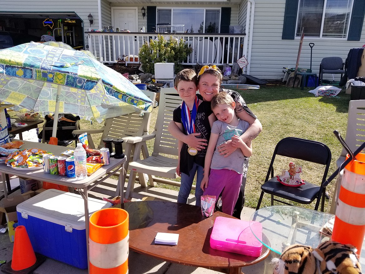 Christa Thompson with two of her children Friday afternoon at her yard sale. The Rathdrum woman was cited for violating Gov. Brad Little's stay-home order. (Image courtesy of Meagan Heyden)