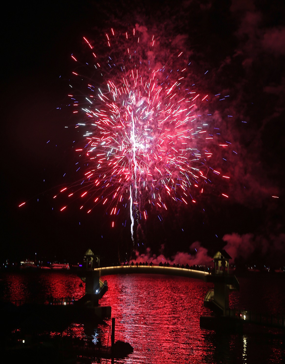 Red and blue fireworks explode over Lake Coeur d’Alene during the Fourth of July celebration.