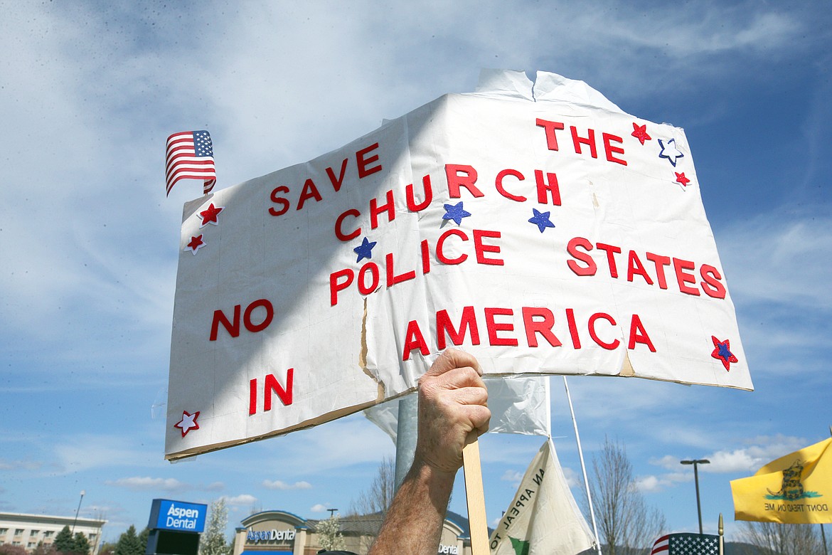 BILL BULEY/Press 
 A sign is held high at Sunday's freedom rally in Coeur d'Alene.