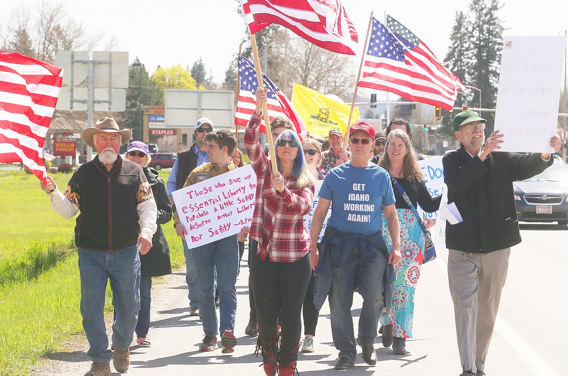 BILL BULEY/Press 
 Kim West, center, leads the freedom march along U.S. 95 in Coeur d'Alene on Sunday.
