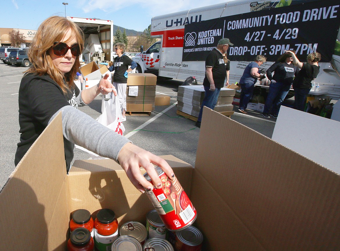 BILL BULEY/Press 
 Becca Pack places donations into boxes at the church food drive on Tuesday at the Silver Lake Mall parking lot.