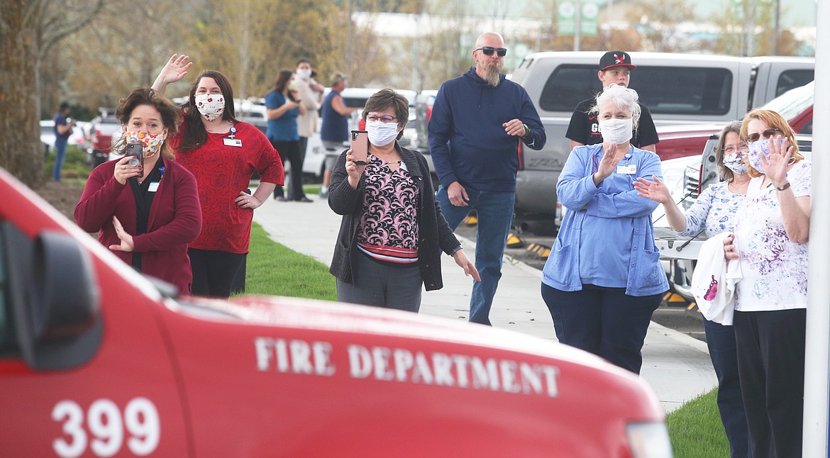BILL BULEY/Press 
 Kootenai Health staff and others wave and watch the parade of emergency vehicles Wednesday.
