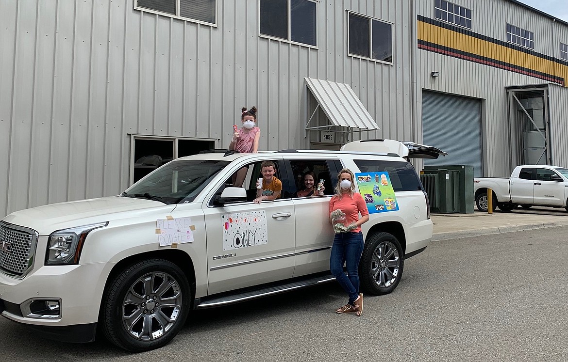 Mom Jamie Green, right, and her ice cream crew snap a photo outside of Ground Force in Post Falls on Wednesday. Green's four kids Scarlett, Sullivan, Sam and Sophia, along with their friend Jimmy Greene, raised $1,110 in ice cream sales including a donation match to give to the Community Action Partnership Coeur d'Alene Food Bank. (Courtesy photo)