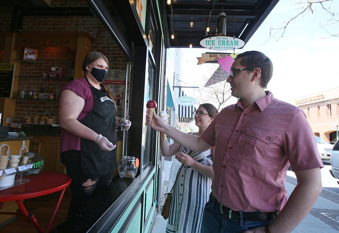 Destiny Hornbuckle and boyfriend Kurt Kelsen, who just moved to Coeur d’Alene a week ago, stopped by Shenanigans on Friday for a huckleberry sorbet and salted caramel pretzel ice cream cone served by Shenanigans employee Haley LeGault. Business owners and customers alike rejoiced to see stores opening after weeks of shutdowns.