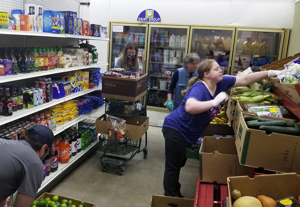 Post Falls Food Bank volunteer Rebecca Cook on Monday reaches for produce items to fill a guest’s basket. The Post Falls Third Street Market is expected to open again for shoppers May 18. (Courtesy photo)